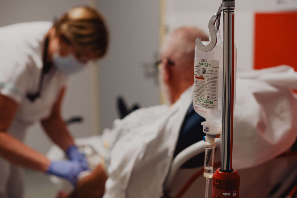 Infirmi&egrave;re posant une perfusion sur un patient &acirc;g&eacute; aux urgences de Verdun.